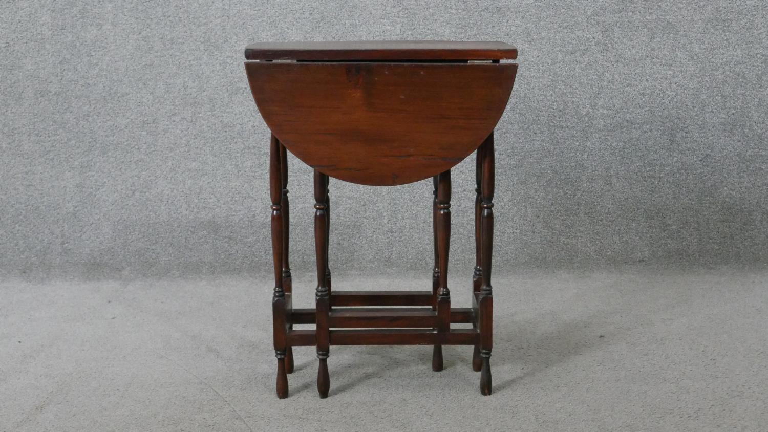 A vintage teak drop flap table on turned stretchered gateleg supports. H.62 W.60 D.45CM