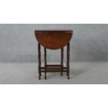 A vintage teak drop flap table on turned stretchered gateleg supports. H.62 W.60 D.45CM