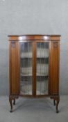 An early 20th century mahogany display cabinet with leaded glazed doors enclosing shelves on