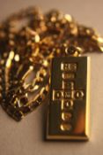 A vintage 9 carat gold ingot pendant and flat curb link chain. Stamped 375, Birmigham, HS. Weight.