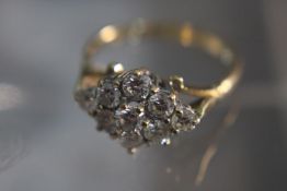 A diamond and 18 carat gold cluster ring. Set with nine round brilliant cut diamonds with a combined