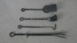 A set of four cast iron fire irons with twisted design handles. L.66cm (largest)