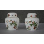 A pair of Coalport hand painted porcelain 'Strawberry' pattern lidded urns. Decorated with flowers