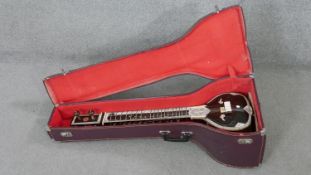 A cased Bina Indian Sitar with stained bone inlaid detailing and makers label. H.30 W.99 D.34cm (
