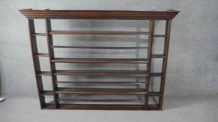 A Georgian country oak plate rack with dentil carved cornice above open shelves. H.125 W.166 D.15cm.