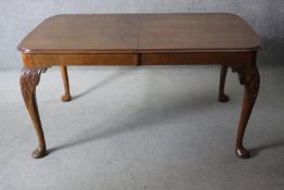 A mid century Queen Anne style burr walnut dining table raised on carved cabriole supports with