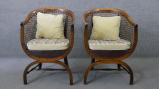 A pair of early 20th century mahogany bergere tub armchairs with fitted tapestry upholstered seats