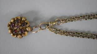 A yellow metal (tests as 9ct gold) fine textured trace watch chain with Albert clasp. Attached to