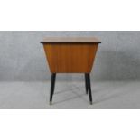 A 1960's vintage teak sewing table with lift out fitted interior and contents, with makers label,