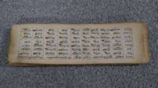 A 19th century hand written Tibetan manuscript on parchment. L.7 W.23 cm