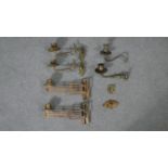 A collection of brass piano sconces, two pairs, one with scrolling foliate design and one with a