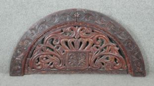 A 20th century carved and pierced Oriental semi circular panel with stylised foliate and floral