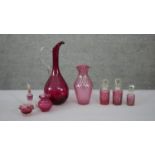 A collection of cranberry glass. Including an art glass water jug, a fishnet pattern golf foil art