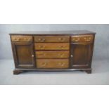 A Georgian country oak dresser base fitted with central drawers with brass swan neck handles flanked