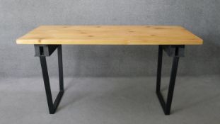 A contemporary pine planked top dining table on metal trestle supports. H.83 W.174 D.72cm