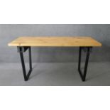 A contemporary pine planked top dining table on metal trestle supports. H.83 W.174 D.72cm