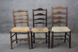 A miscellaneous collection of three 19th century oak ladder back dining chairs with rush seats.