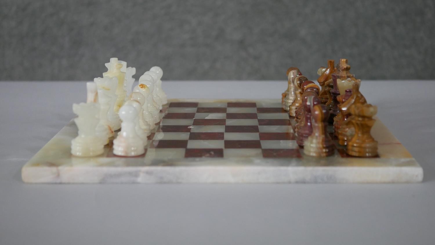 A vintage hand carved alabaster chess set with alabaster chess board. (Complete) H.1 W.30 D.30cm (