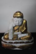 An early 20th century large Oriental carved white marble seated Buddha with gilded detailing and