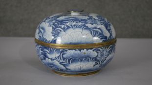 A Thai hand painted blue and white enamel on brass lidded box with lotus leaf and pod design.