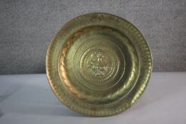 A large 19th century repousse brass charger with urn design to the centre and lettering to the edge.
