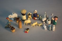 A collection of eighteen miniature items. Including A Kobe charm with retractable eyes, a lead