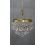 A 20th century crystal drop and brass two tier waterfall chandelier with crystal flower detailing.