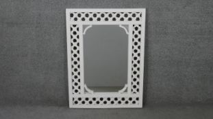 An Indian painted white geometric pierced design wall mirror. H.88 W.65cm