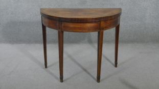 A Georgian mahogany demi lune fold over top card table with satinwood line inlay and gateleg
