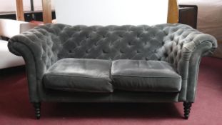 A contemporary Sofa.com Chesterfield sofa in deep buttoned velour upholstery on ring turned tapering