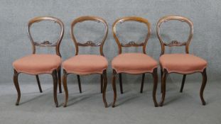 A set of four Victorian carved mahogany balloon back dining chairs on cabriole supports.