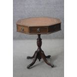 A Georgian style mahogany drum table with inset tooled gilt leather top on quadruped reeded swept