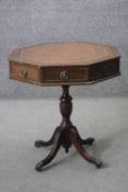 A Georgian style mahogany drum table with inset tooled gilt leather top on quadruped reeded swept
