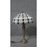 A Tiffany style coloured stained glass lace design table lamp with gilt metal foliate design