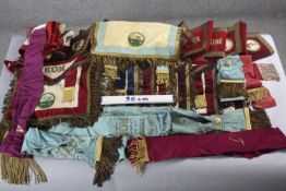 A large collection of approximately thirty pieces of Masonic regalia. Including tunics, sashes,