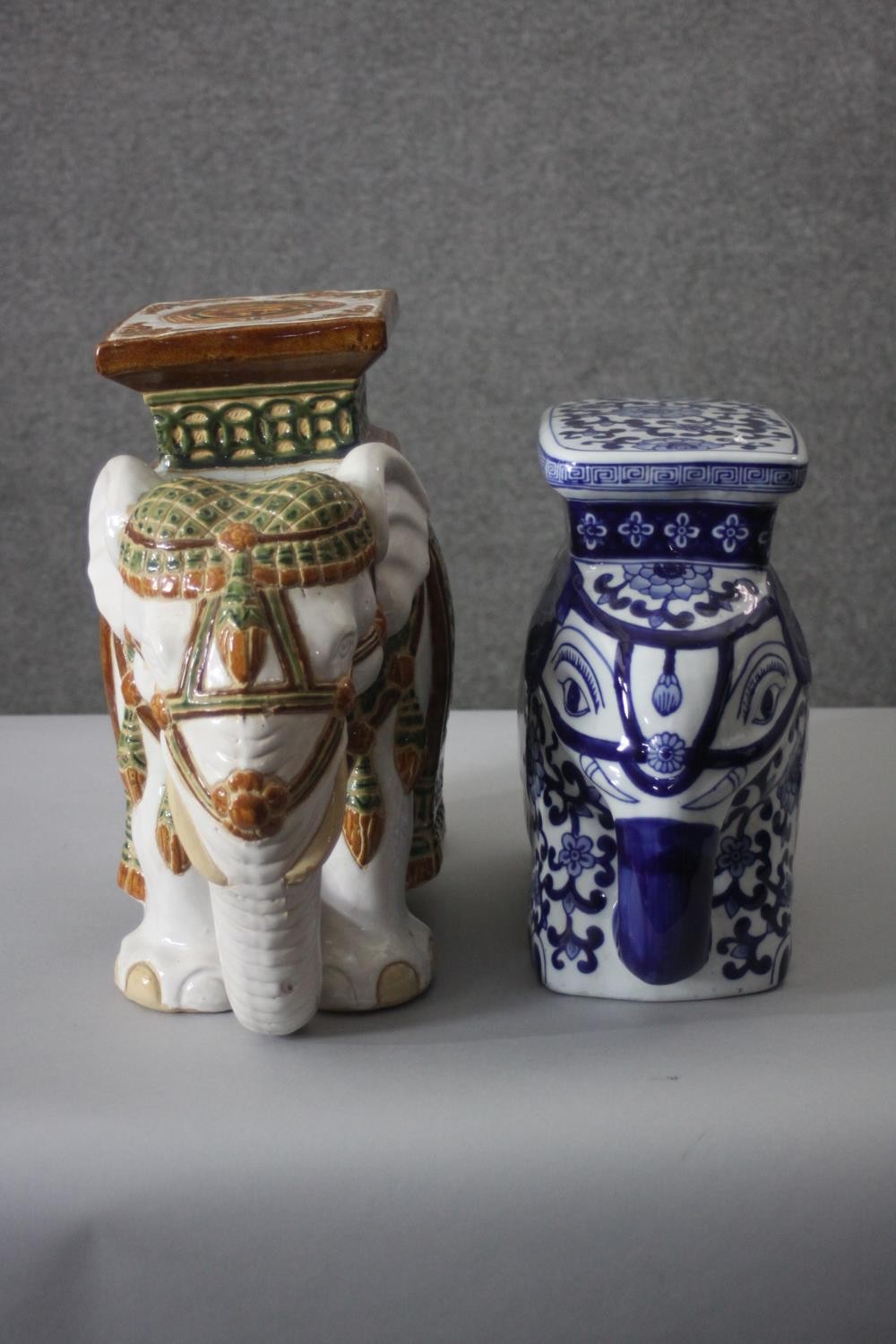 Two hand painted ceramic elephant stools. One blue and white in the Chinese style and the other with