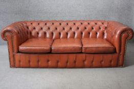 A three seater Chesterfield sofa in deep buttoned and studded leather upholstery. H.64 W.200 D.90