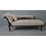 A Victorian carved walnut framed chaise longue on turned tapering supports. H.73 W.157 D.59cm