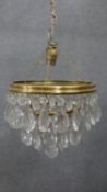 A 20th century crystal drop and brass two tier waterfall chandelier with crystal flower detailing.