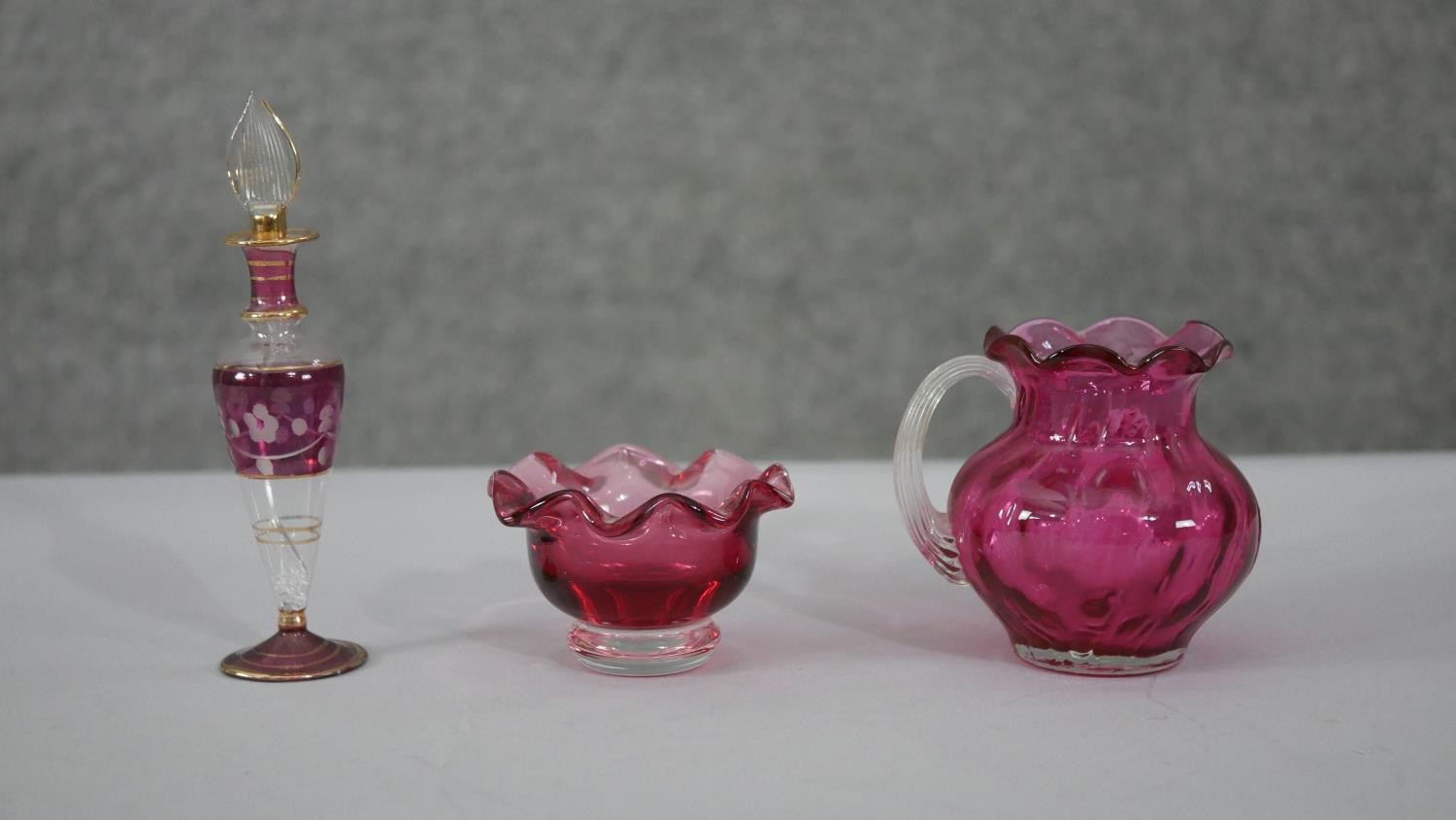 A collection of cranberry glass. Including an art glass water jug, a fishnet pattern golf foil art - Image 6 of 6