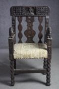 A mid 16th century oak child's throne chair with head and shoulder carving of a head wearing a crown