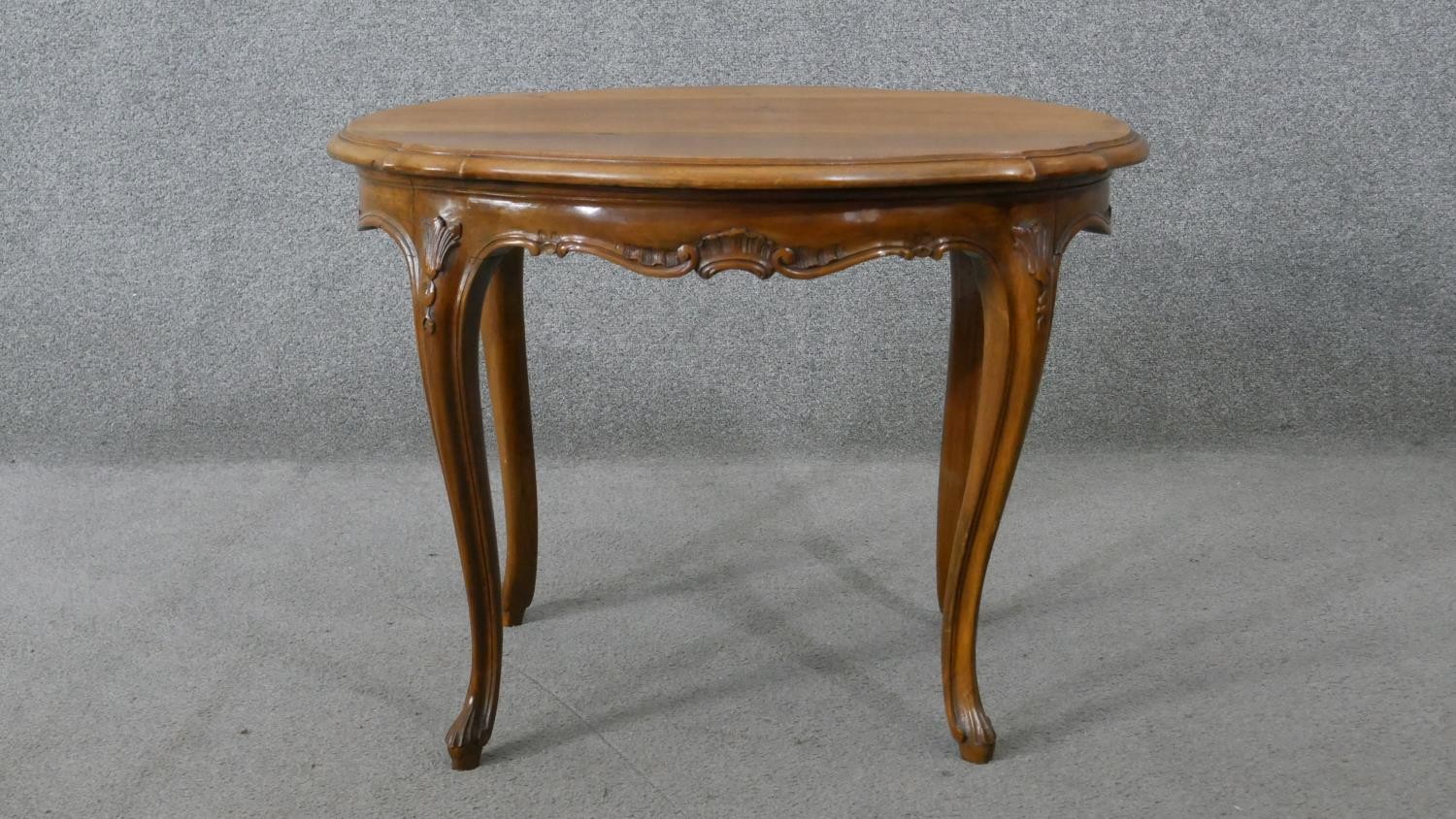 A Continental style walnut centre table on carved cabriole supports. H.55 W.72 D.54CM