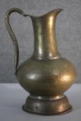 A large early 20th century engraved brass water jug with stylised floral and foliate design. H.40