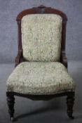 A 19th century carved walnut framed nursing chair in floral upholstery on turned tapering supports.