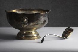 A Victorian silver plated pedestal punch bowl with lion head handles and foliate design repousse