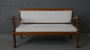 A vintage teak North European style open armed hall seat with upholstered back and drop in seat on