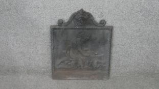 A 19th century French cast iron relief design fireback. It depicts a young child kneeling warming