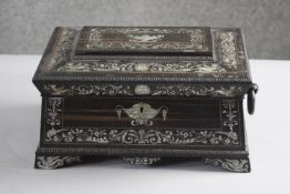 A 19th century Coromandel and mother of pearl inlaid sarcophagus sewing box with paper lined lift