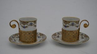 Two Limoges hand painted coffee cups with stylised floral and foliate design. Each with a pierced