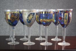 A set of eight hand painted stained glass effect wine glasses with various designs. H.25 Dia. 11cm.